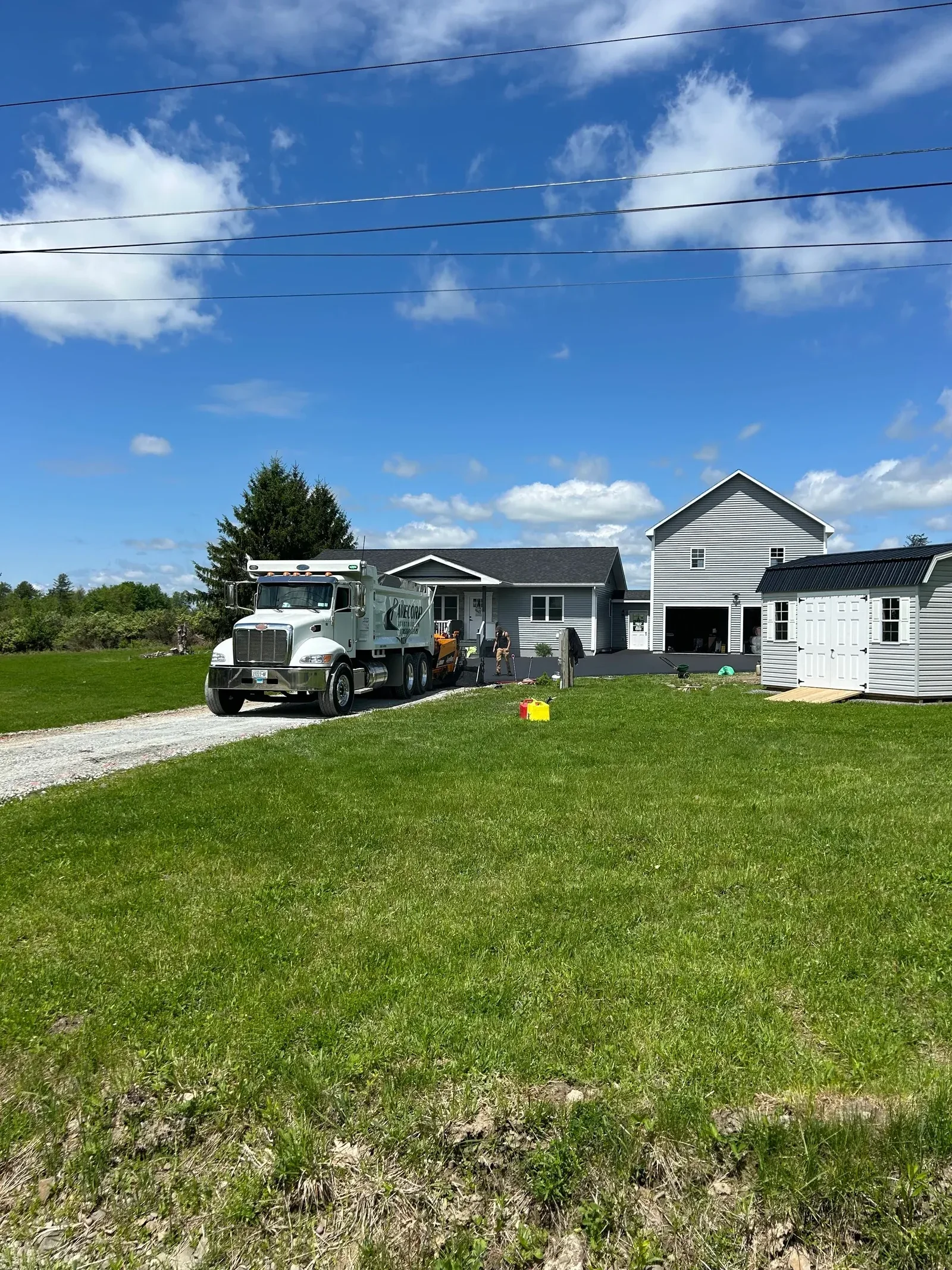 Newly paved asphalt driveway with finished surface alongside residential home