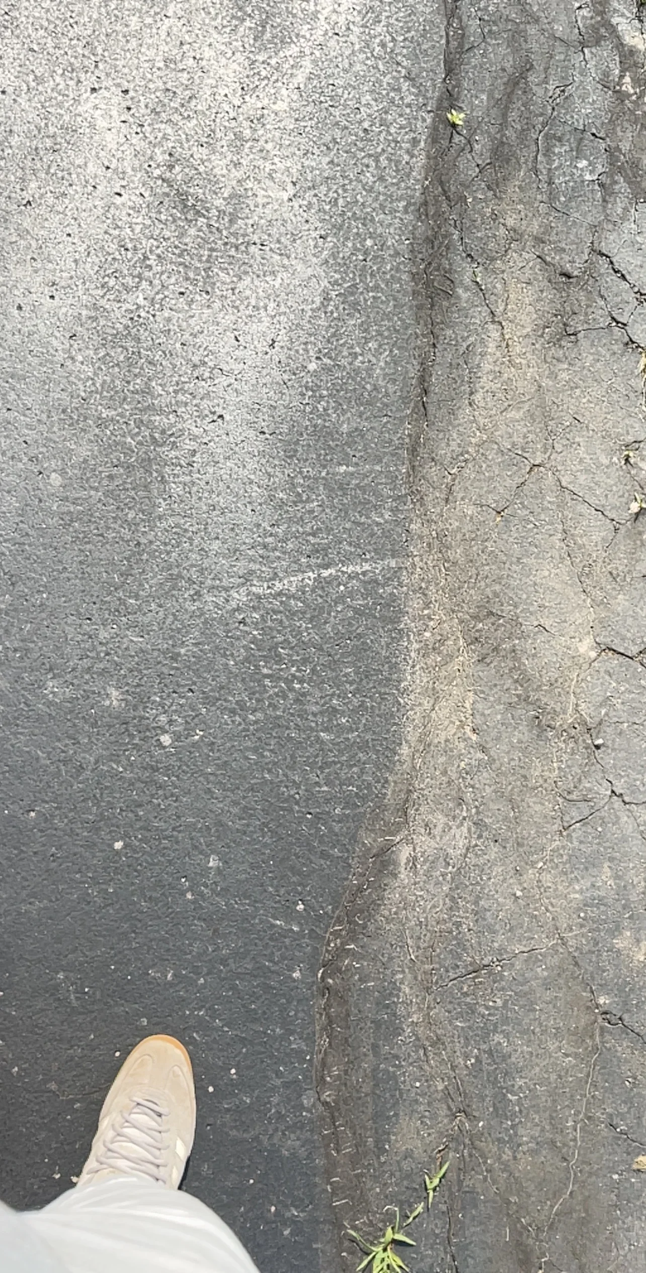 Concrete surface with sealed cracks and repair work, showing before-and-after treatment