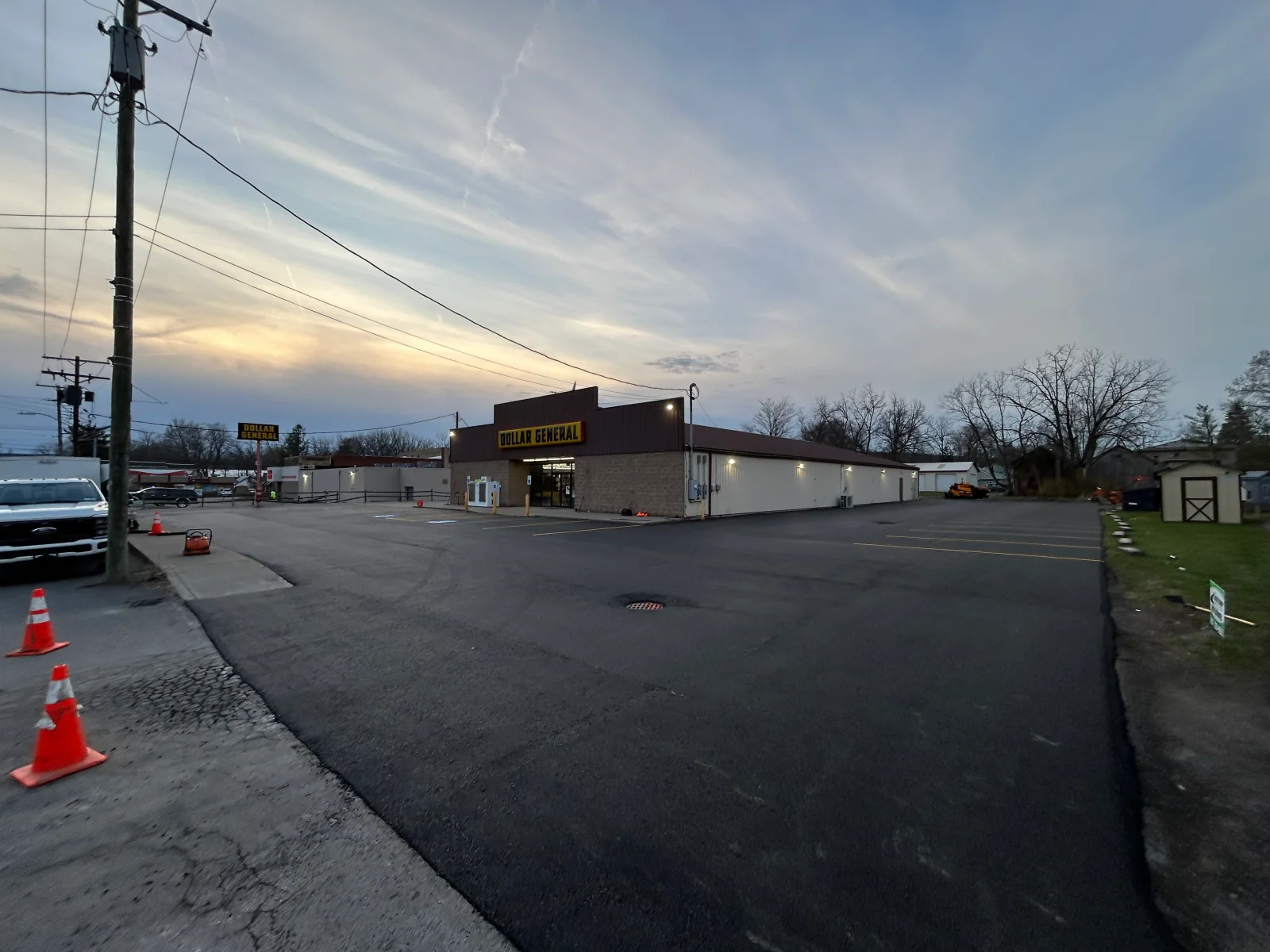 Newly paved commercial asphalt parking lot with traffic cones and fresh asphalt surface