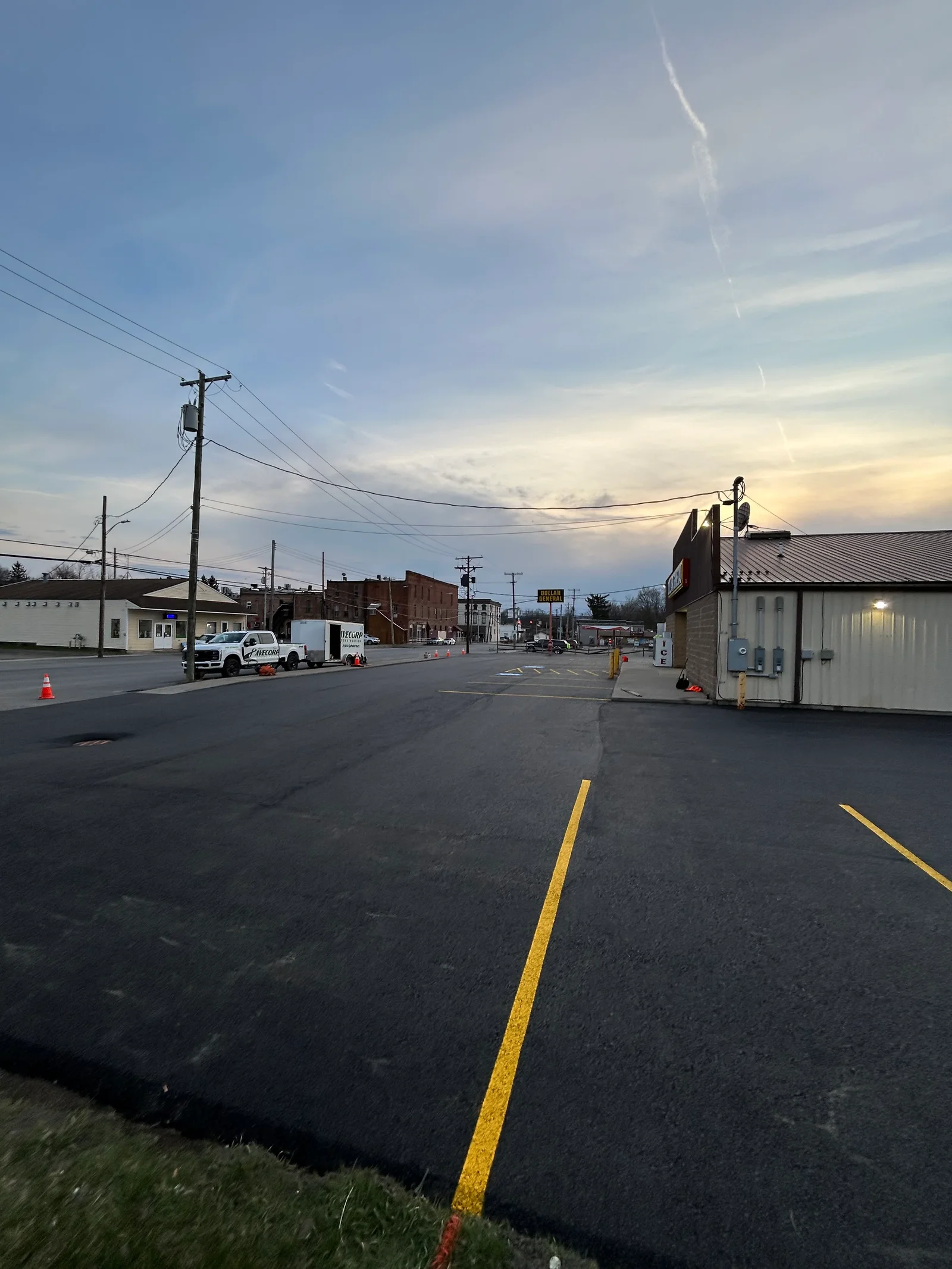 Newly paved asphalt parking lot with yellow line striping and directional markings