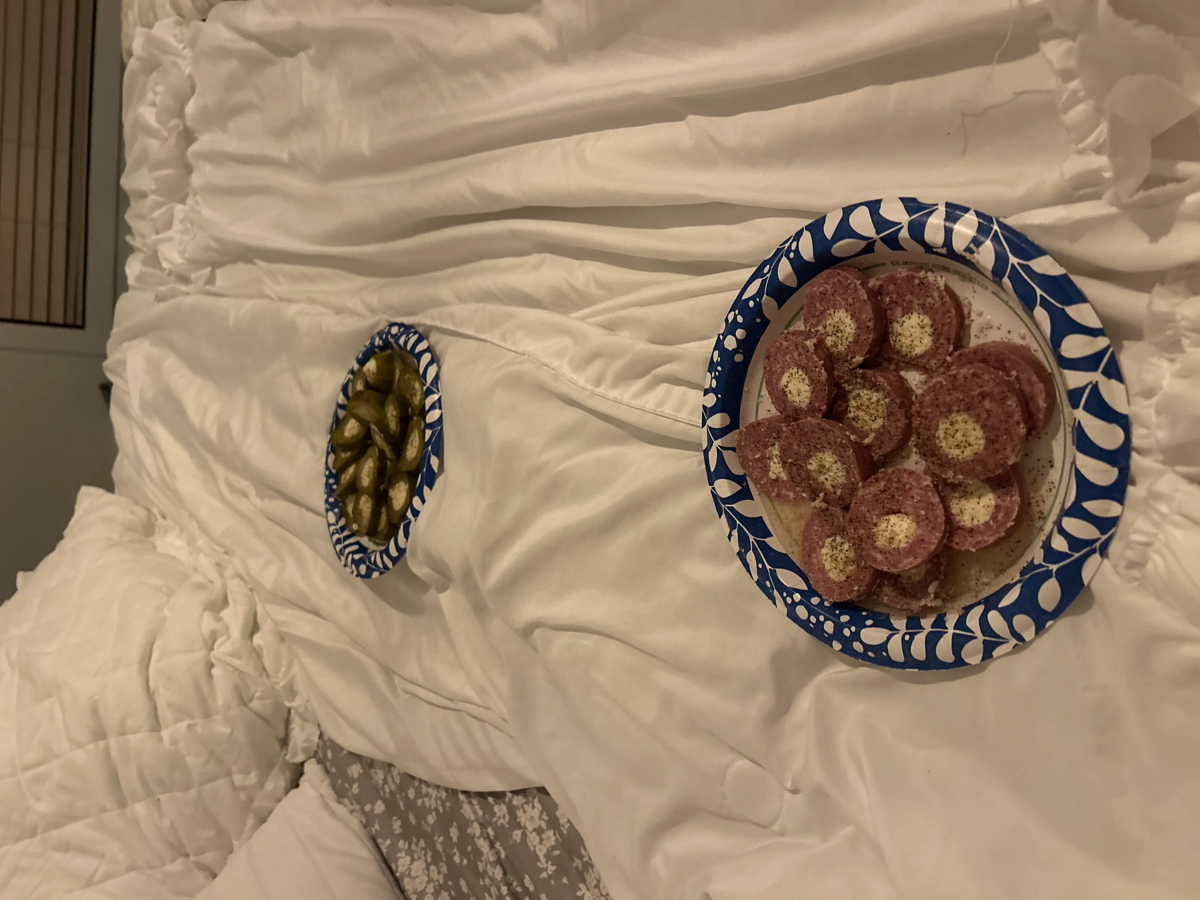 Blue and white ceramic plates with decorative leaf patterns on quilted white fabric