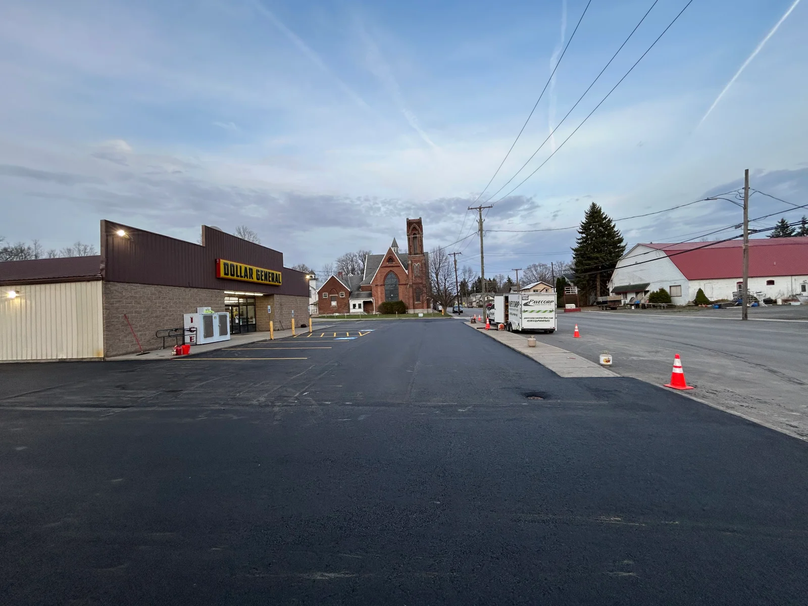 Newly paved asphalt parking lot with white striping and parking space markings