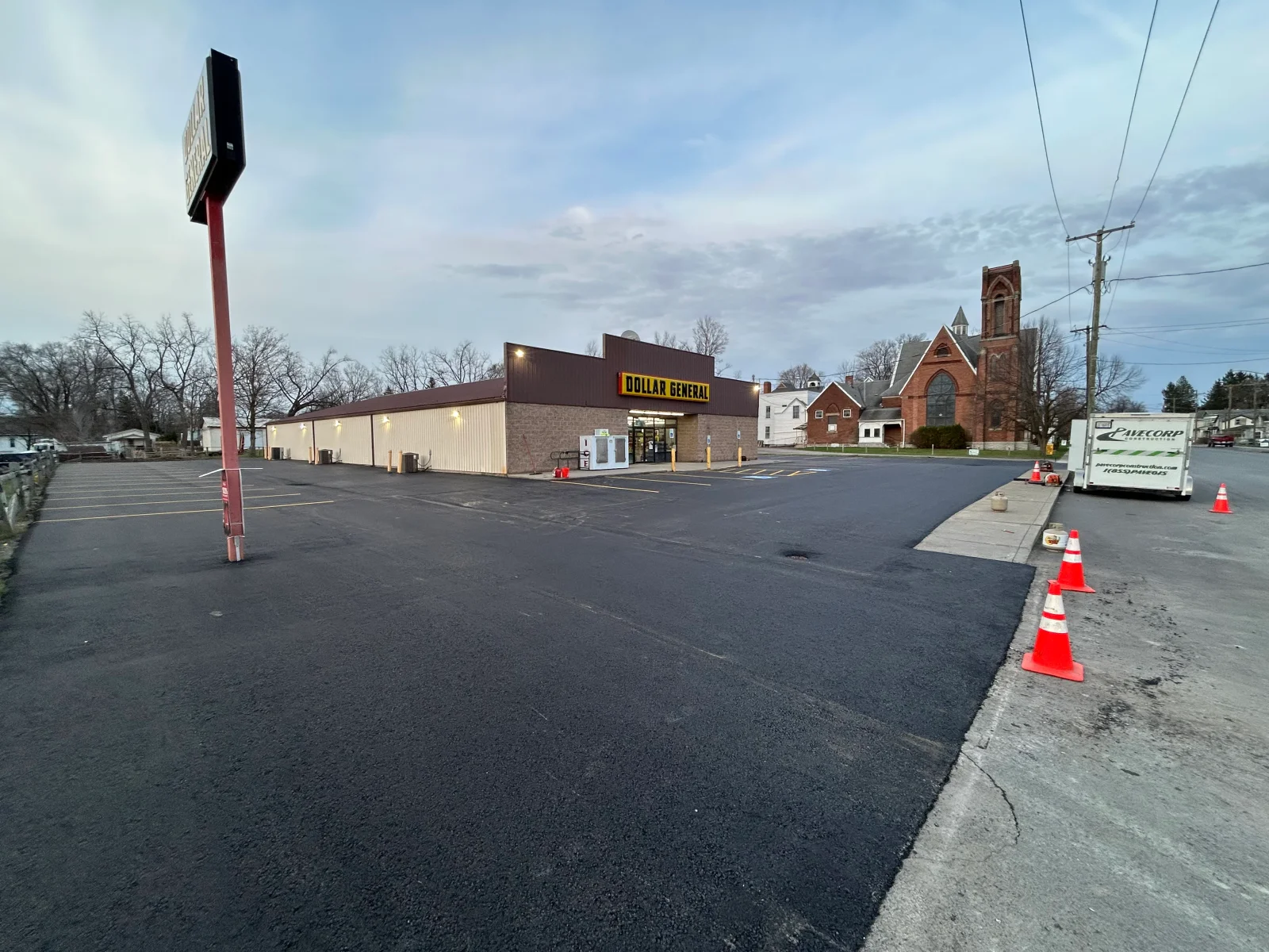 Newly paved asphalt parking lot with traffic cones and fresh black asphalt surface